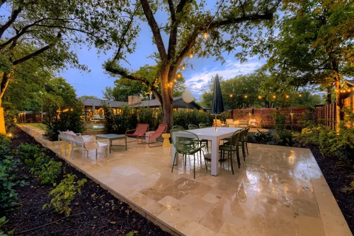 Spacious outdoor entertaining area with multiple seating zones and warm ambient lighting