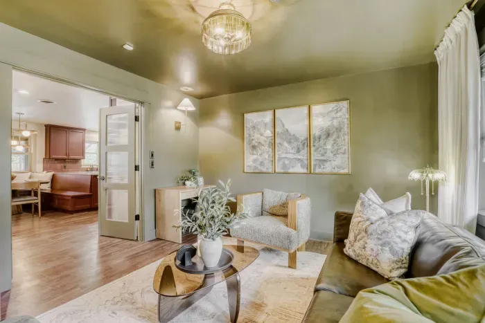 Refined sitting room with rich green tones and soft natural light, a quiet retreat for conversation or reading