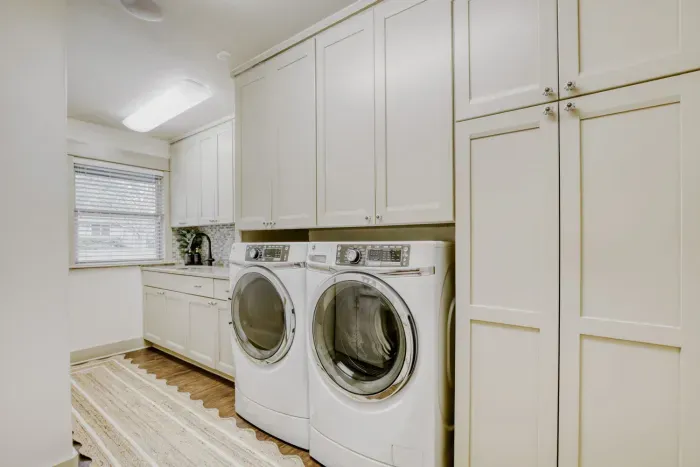 Functional laundry room with abundant cabinetry and counter space, designed to keep everything organized and efficient