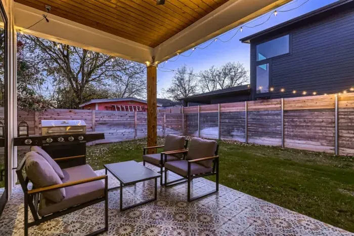 Spacious backyard with a covered patio area for dining, lounging, or entertaining.