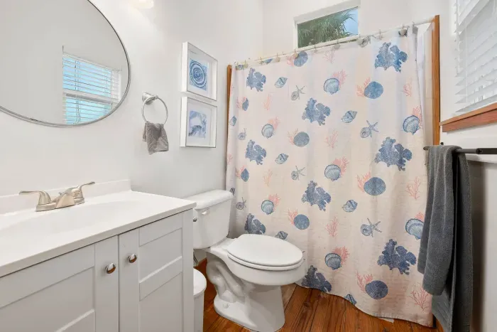 Clean and refreshing bathroom with a tub and bright vanity mirror.