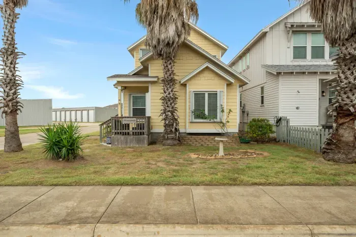 A charming coastal exterior with palm trees and beach-town character welcoming you to your Port Aransas getaway.