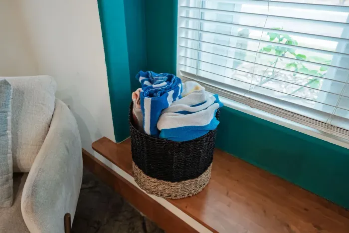 Soft coastal textures and bright windows create a peaceful living retreat.