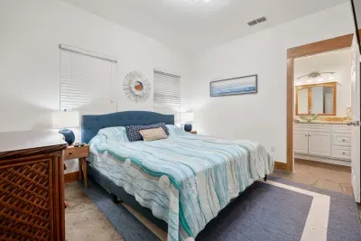 Relaxing primary suite with plush bedding and serene coastal tones.