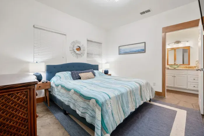 Relaxing primary suite with plush bedding and serene coastal tones.