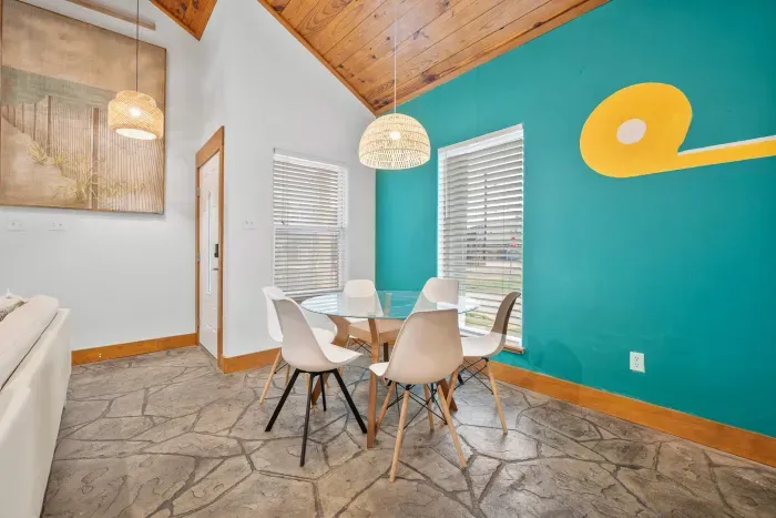 A stylish dining room with vibrant coastal colors and natural light offering the perfect space for relaxed seaside meals.