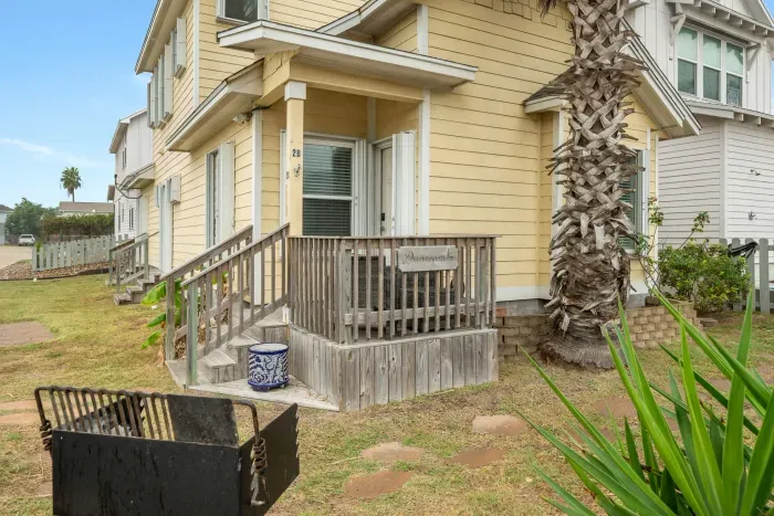 Side view of the home showing easy access, driveway space, and palm trees.