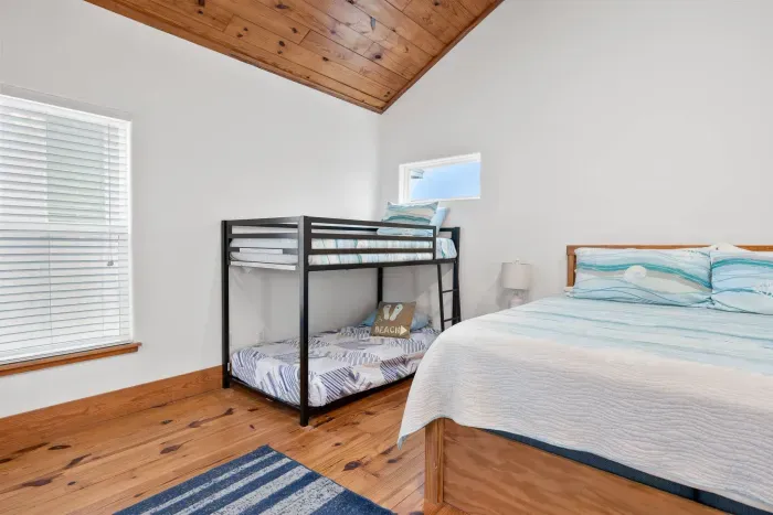 Another view of the bunk room showcasing extra space and soft natural lighting.
