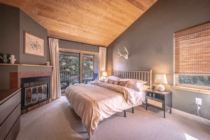 Serene primary bedroom with soft lighting and beautiful hillside views.