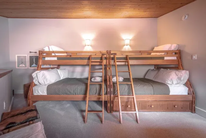 Bright bunk room with comfortable beds and cabin-style finishes.