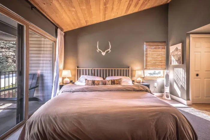 Spacious bedroom with a plush bed and private balcony access.