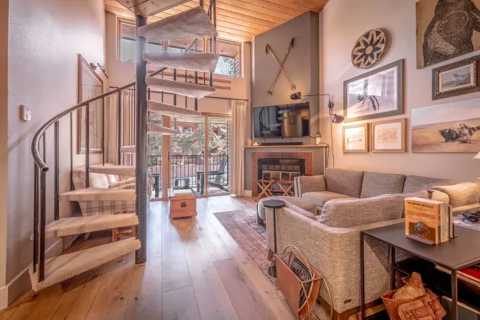 Warm sunlit living room with cozy seating and mountain cabin charm.