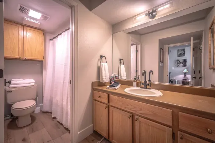 Clean full bathroom with convenient shower and storage.
