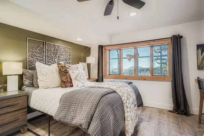 Primary bedroom featuring a luxurious king bed and mountain views.