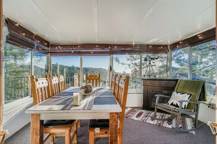 Sunroom dining area surrounded by panoramic mountain views.