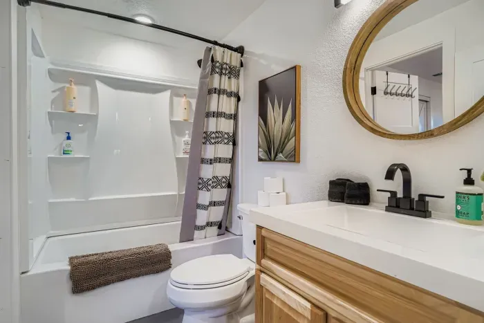 Bright full bathroom with a soaking tub and rainfall showerhead.