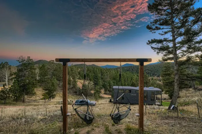 Peaceful backyard with rustic swings and panoramic mountain views.