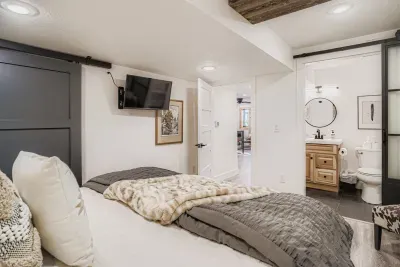 Elegant primary suite with TV, ensuite, and warm natural light.