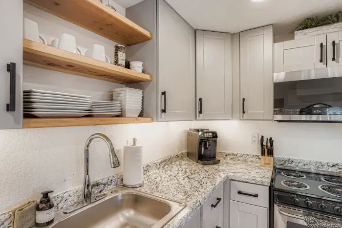 Sleek kitchen setup with coffee bar and granite countertops.