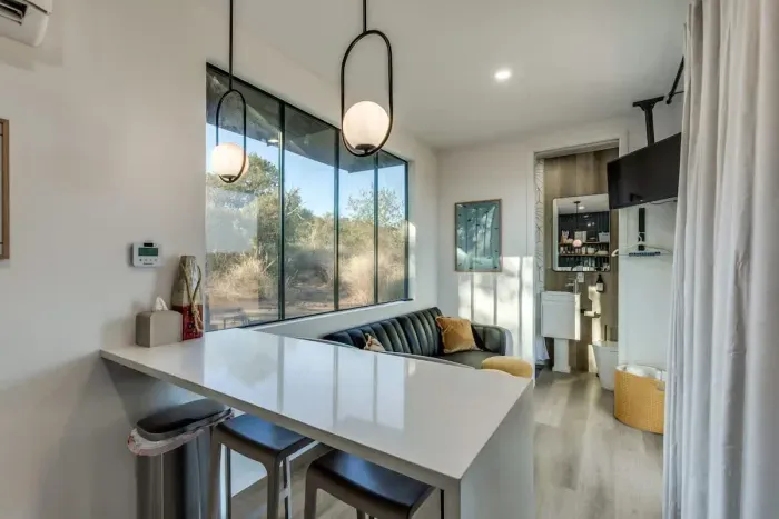 Stocked kitchen with microwave and cooktop with waterfall kitchen peninsula doubling as a workspace and cooking area