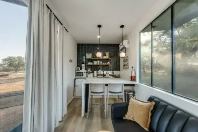 Pull-full sofa bed with to seats at the waterfall kitchen peninsula doubling as a workspace and cooking area