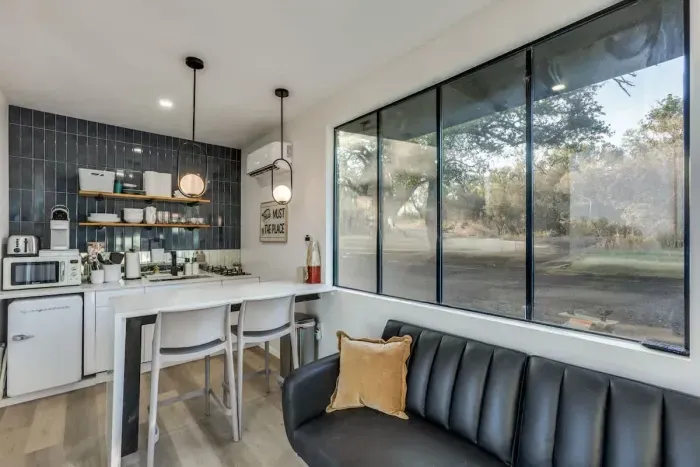 Pull-full sofa bed with to seats at the waterfall kitchen peninsula doubling as a workspace and cooking area