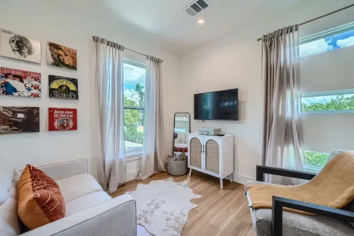 Professionally decorated living area with high end furniture, natural light, and Smart TV