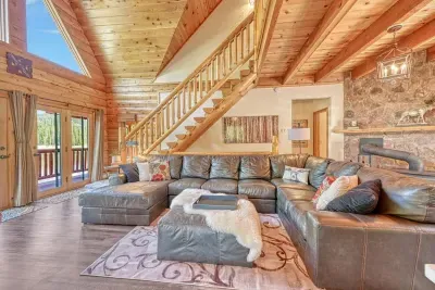 4. Welcoming living room featuring a large, comfortable sofa and tasteful wood accents, creating a warm and inviting atmosphere. This stylish space is perfect for relaxation and entertaining, offering a blend of comfort and natural charm.