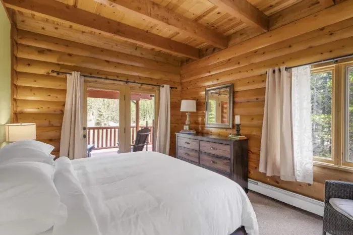 Bright and airy bedroom with large windows and blackout curtains for ultimate comfort.