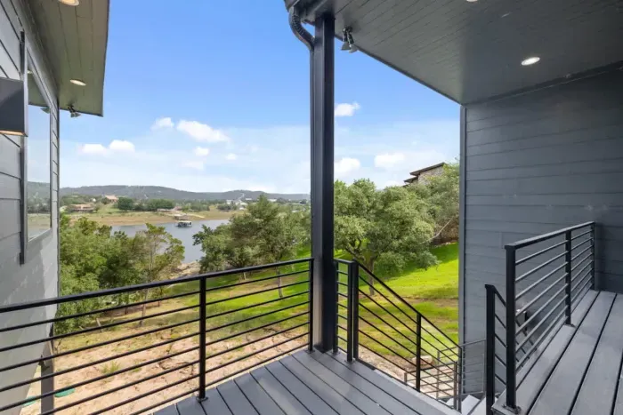 Balcony view with serene lake and hill country backdrop.