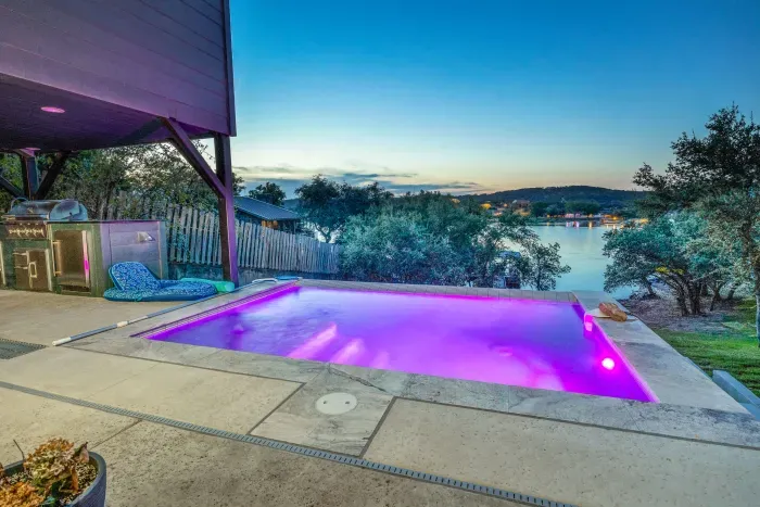 Pool lit beautifully at night with wide hill country views.