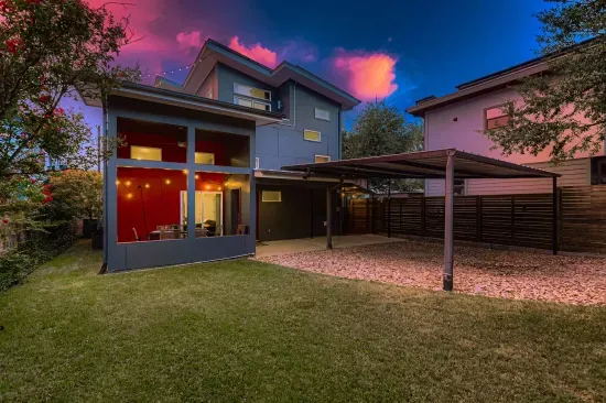 Twilight view of the home with spacious yard and modern design.
