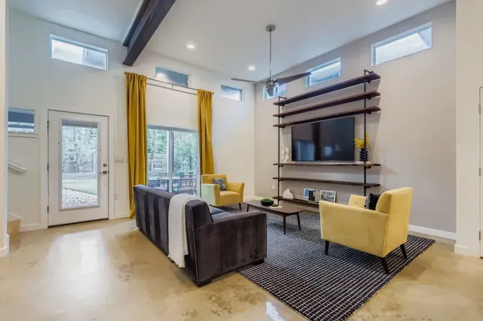 Bright and stylish living room with floor-to-ceiling windows and cozy seating.