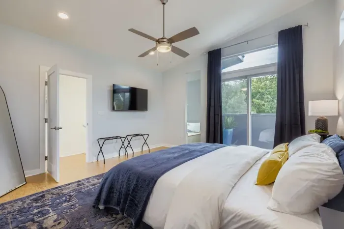 Spacious master bedroom with king bed and wall-mounted TV.