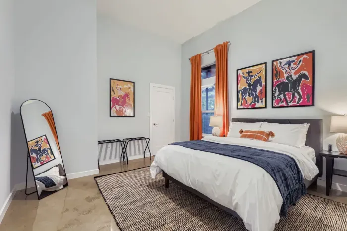 Spacious bedroom with comfortable bedding and bright pops of color.