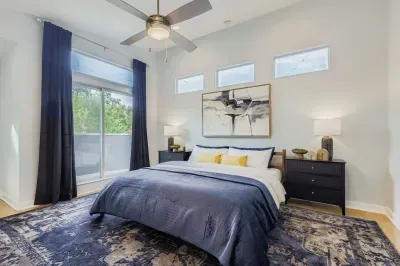 Natural light fills the master bedroom with cozy bedding.