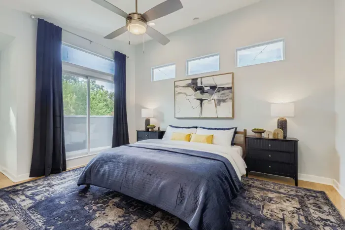 Natural light fills the master bedroom with cozy bedding.