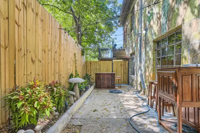 Step outside to a private patio area with seating and greenery, perfect for enjoying fresh air in a quiet setting