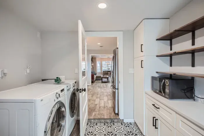 Convenient laundry room with modern appliances and plenty of counter space for folding.