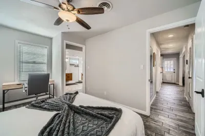 Enjoy a bright and airy bedroom, featuring large windows that flood the space with natural light. The room is fitted with blinds for privacy and light control, creating a fresh, inviting atmosphere for relaxation.