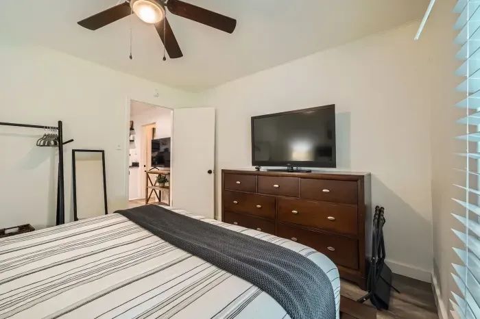 Cozy bedroom with a dresser and flat-screen TV.