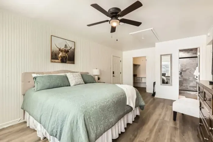 Modern primary bedroom with minimalist design and high-quality bedding.