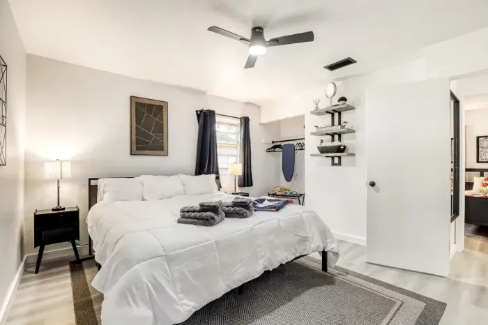 Spacious primary bedroom with plush king bed, soft lighting, and a calm, uncluttered design for deeper rest