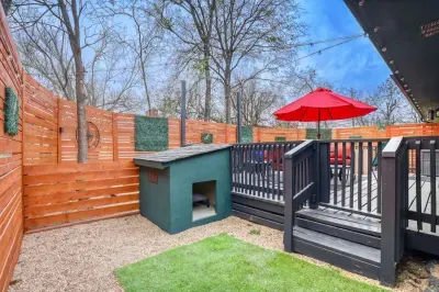 Private backyard with dedicated dog house and pet-friendly space, plus a raised deck for relaxing just steps away