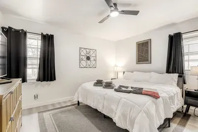 Bright and relaxing bedroom with blackout curtains, fresh linens, and thoughtful touches for a restful night