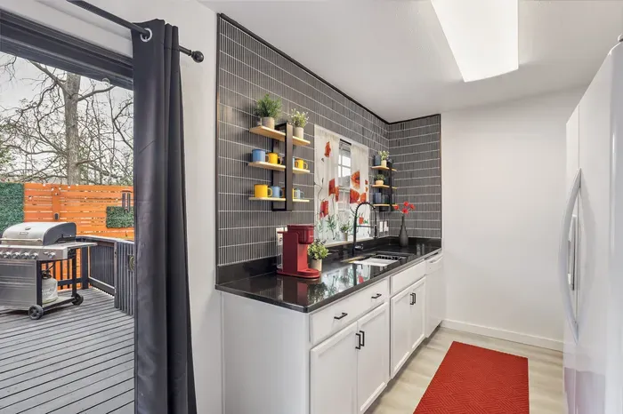 Modern kitchen with coffee station and direct access to the private patio and grill for easy indoor-outdoor living