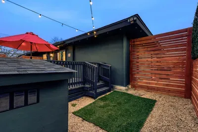 Private, dog-friendly backyard with secure fencing, turf space, and a cozy, string-lit patio