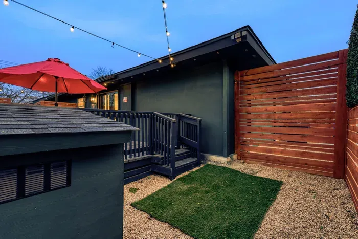 Private, dog-friendly backyard with secure fencing, turf space, and a cozy, string-lit patio