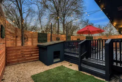 Private outdoor area featuring a built-in dog house and fenced yard, perfect for guests traveling with pets