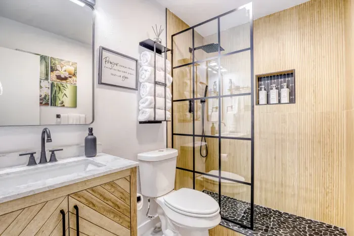 Modern bathroom with walk-in glass shower, rainfall head, and clean finishes for a spa-like start or end to your day